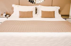 a bed with white sheets and pillows at Hotel Rieger in Balneário Camboriú +119 photos