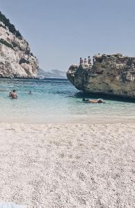 a group of people in the water on a beach at Casa Anna in Ilbono +37 photos