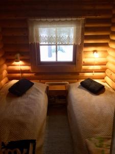 ルオストにあるVilla Luppopirttiの窓のある部屋にベッドが2つある