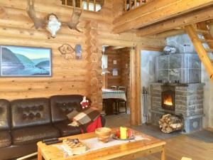ein Wohnzimmer mit Sofa und Kamin in der Unterkunft Villa Luppopirtti in Luosto