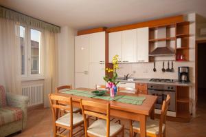 a kitchen with a table and chairs and a kitchen with a stove at Appartamenti Baia Azzurra 4. in Nago-Torbole