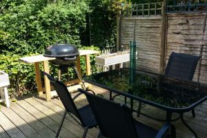 a patio with a grill and chairs and a table at Basingstoke Townhouse in Basingstoke