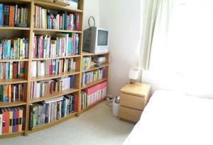 a bedroom with book shelves filled with books at Basingstoke Townhouse in Basingstoke