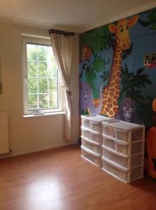 a room with a giraffe and other animals on the wall at Basingstoke Townhouse in Basingstoke