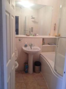 a bathroom with a sink and a bath tub and a sink at Basingstoke Townhouse in Basingstoke