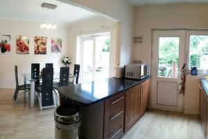 a kitchen with a counter top and a table with a microwave at Basingstoke Townhouse in Basingstoke