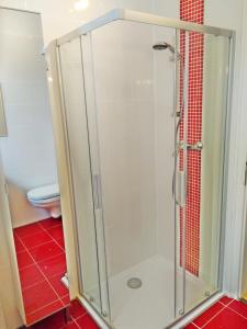 a shower stall in a bathroom with red tiles at Wohnen im Herzen der romantischen Cochemer Altstadt in Cochem