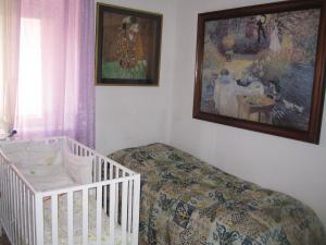 a room with a crib and a painting on the wall at Residence Luisa in Avezzano