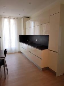 a kitchen with white cabinets and a black counter top at Charming Apartment on the boarder of Monaco in Beausoleil