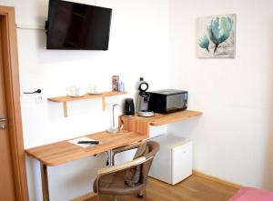 a room with a desk and a tv on a wall at Gästehaus Neckarsulm in Neckarsulm