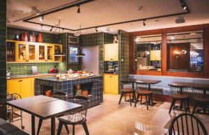 a restaurant with tables and chairs and a kitchen at HENRI Hotel Düsseldorf in Düsseldorf