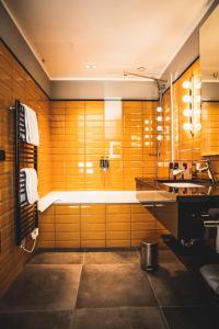 a bathroom with a tub and a sink at Henri Hotel Düsseldorf Downtown in Düsseldorf