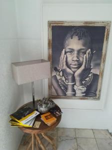 une photo d'un garçon noir sur un mur à côté d'une table dans l'établissement Guest House TOWERCC, à Figueiró dos Vinhos