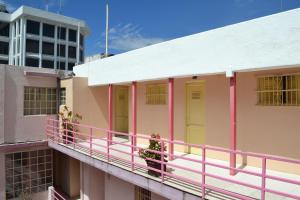 a building with pink and yellow doors on a balcony at Hotel Maya in Guadalajara