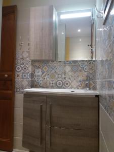 uma casa de banho com um lavatório e um espelho em Le nid d'aigle em Arêches