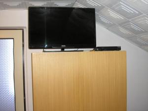a flat screen tv on top of a wooden cabinet at Bungalow Škrabálek in Rokytnice nad Jizerou