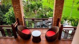 un balcón con 2 sillas y una mesa en un porche en Hoi An Golden Rice Villa, en Hoi An