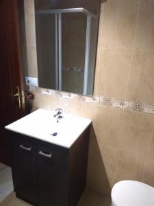 a bathroom with a sink and a mirror and a toilet at Piso Almería playa in Almería +12 photos