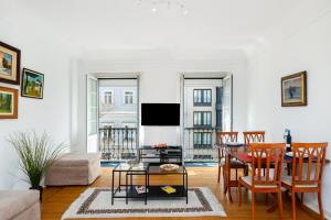 リスボンにあるWHome | Marquês Premium Apartmentのリビングルーム(テーブル、椅子、テレビ付)
