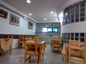 a dining room with tables and chairs and a window at Sokulski Park Hotel in Araucária