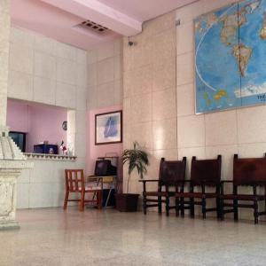 a waiting room with chairs and a map on the wall at Hotel Maya in Guadalajara