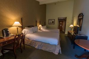 una camera d'albergo con un grande letto e una scrivania di Interlaken Inn a Lakeville