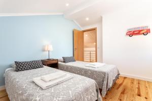 1 dormitorio con 2 camas y un autobús rojo en la pared en As Serenas Casa C, en Vila Nova de Cacela 23 fotos más