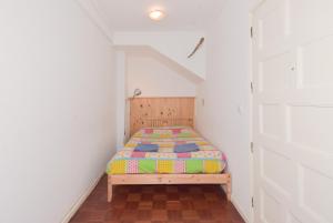 1 dormitorio pequeño con 1 cama en una habitación blanca en Alegria Downtown, en Oporto