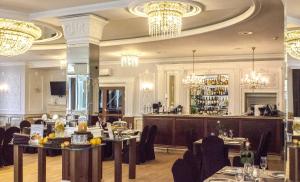 a restaurant with tables and chairs and chandeliers at Jasek Premium Hotel Wrocław in Wrocław