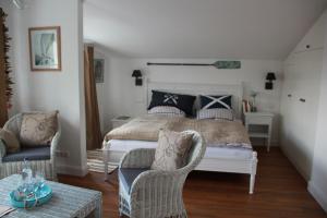 a bedroom with a bed and two chairs at Hotel Lili Marleen in Travemünde +160 photos
