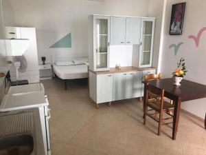 a small kitchen with a table and a bed at Appartamenti La Spiaggia in Gallipoli
