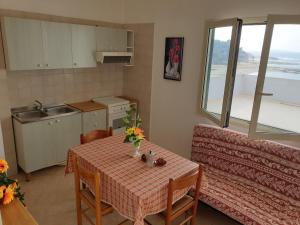 una pequeña cocina con mesa y sofá en Appartamenti La Spiaggia en Gallipoli