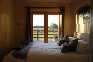 a bedroom with a large bed with a large window at Honeysuckle in Hadleigh +15 photos