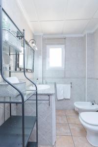 Villa Lago Sol في توريفايجا: حمام أبيض مع حوض ومرحاض