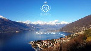 a town on a lake with mountains in the background at Hotel Meridiana in Bellano