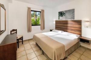 a hotel room with a large bed and a desk at Sol Sun Beach Apartamentos in Adeje
