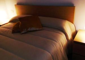un grande letto bianco con testiera in legno in una stanza di La Dimora dei Longobardi Studio Apartment a Salerno