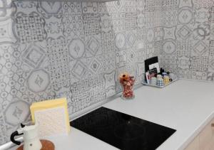 un bancone della cucina con parete bianca e grigia di La Dimora dei Longobardi Studio Apartment a Salerno