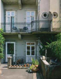 a building with a balcony with chairs and plants at Rosa Et Al Townhouse in Porto