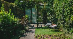 a garden with two chairs and a table at Rosa Et Al Townhouse in Porto