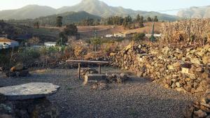 una pared de piedra con una mesa de picnic y un banco en Casitas La Montañita, en El Paso