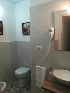 a bathroom with a toilet and a phone on the wall at B.HOUSE in Cagliari