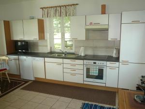 a kitchen with white cabinets and a stove top oven at Weinbergstöckl Gombotz in Neuhaus am Klausenbach