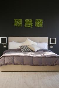 1 dormitorio con 1 cama con 2 plantas verdes en la pared en Royal Suite, en Tissi