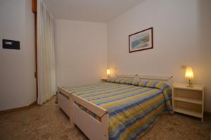 małą sypialnię z łóżkiem i szafką nocną w obiekcie Ville Park Hotel w Bibione