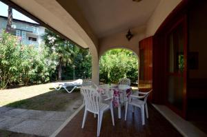 a porch with a table and chairs on a patio at Ville Park Hotel in Bibione