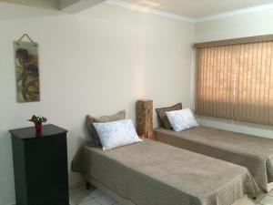 um quarto com duas camas e uma janela em Aconchego e conforto em Joanópolis em Joanópolis