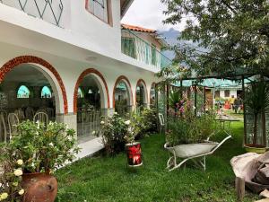 a garden with plants and a chair in the grass at Hotel Bellavista in Huaran