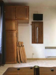 eine Küche mit Holzschränken und einem TV an der Wand in der Unterkunft Résidence Les Ecrins in Les Orres