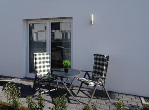 2 Stühle und ein Tisch auf der Terrasse in der Unterkunft Ferienapartment im Augustinus Park in Trier